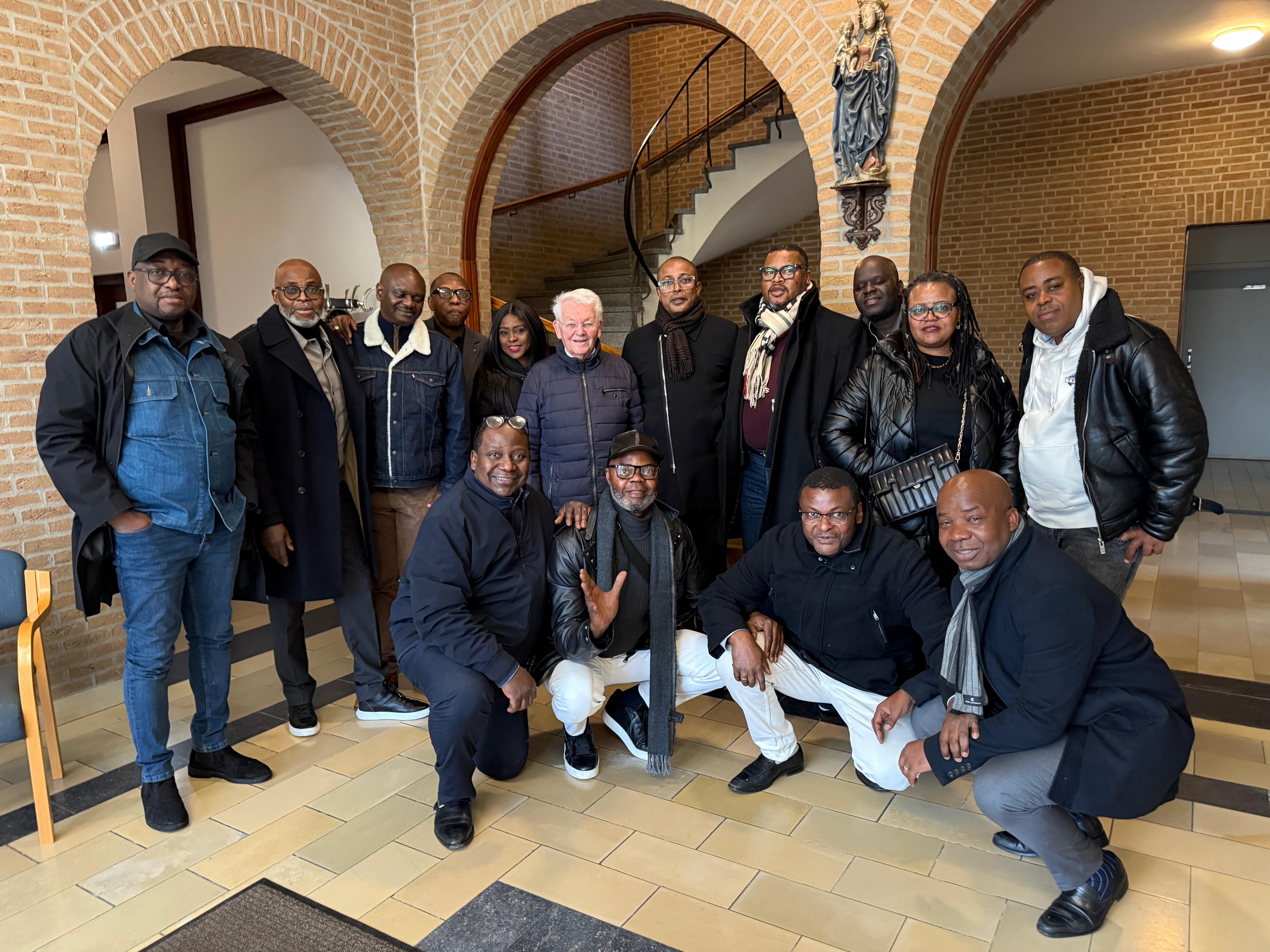 Rencontre des membres de New Life CMS – Visite des Pères formateurs à Heverlee (Belgique). Un moment de fraternité et de recueillement auprès des Pères Fons et André Rosier, témoignant de la reconnaissance et du respect envers les formateurs du Collège Kubama.